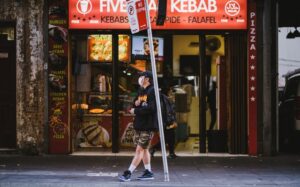 man standing outside shop during coronavirus with mask